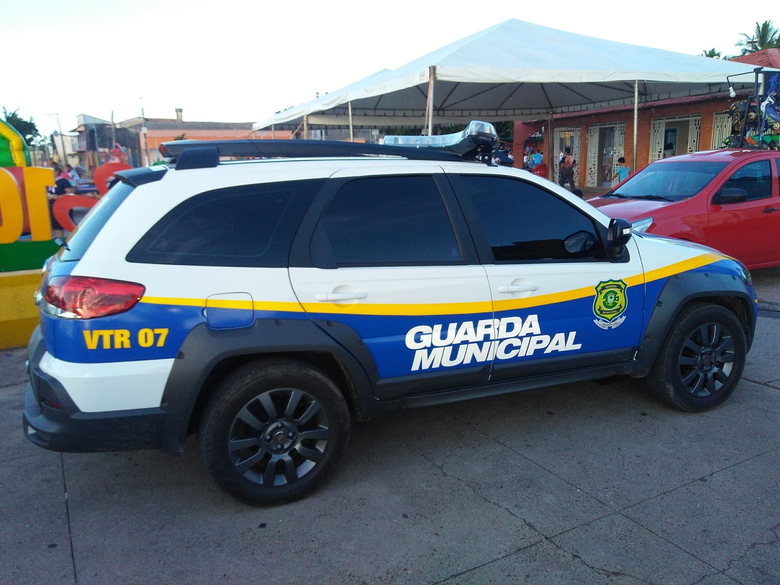 Guarda Municipal que defende câmeras para multar motoristas aparece balançando bandeira política em teto solar de carro