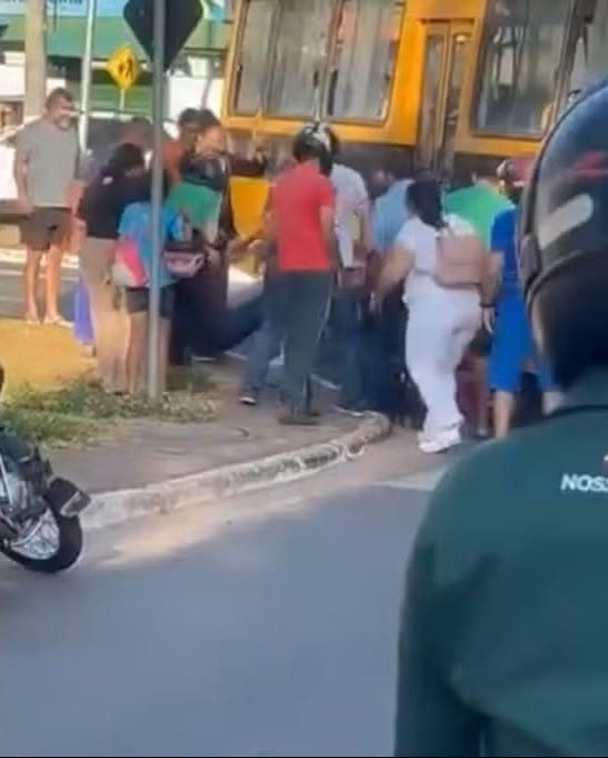 Motociclista é retirada debaixo de ônibus escolar por pedestres após acidente