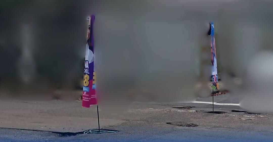 Cena inusitada: bandeiras de propaganda política são fixadas em buracos no asfalto em Araras, SP