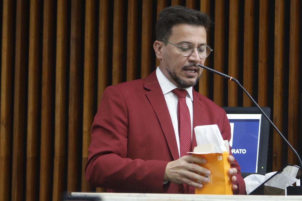 De terno e gravata vermelhos, Arilson oferece lenços e detergente a bolsonaristas na Alep